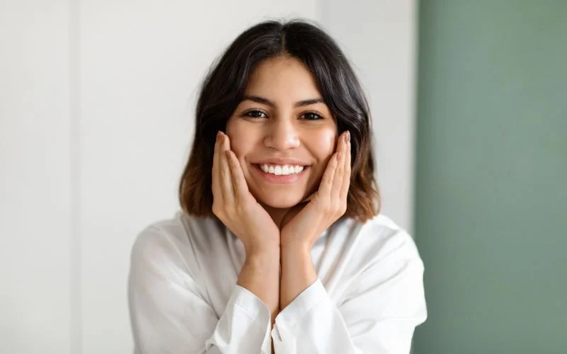 female model posing with her hands on cheek