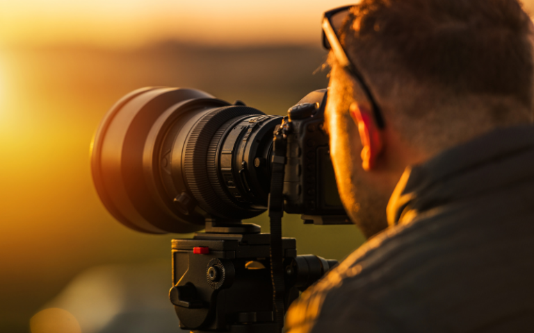 A photographer capturing sunset with his camera