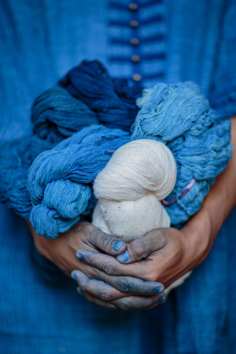 A man holding balls of yarn dyed with indigo using traditional dyeing methods, Indigo Dyeing Factory, Sakhon Nokhon, Thailand
