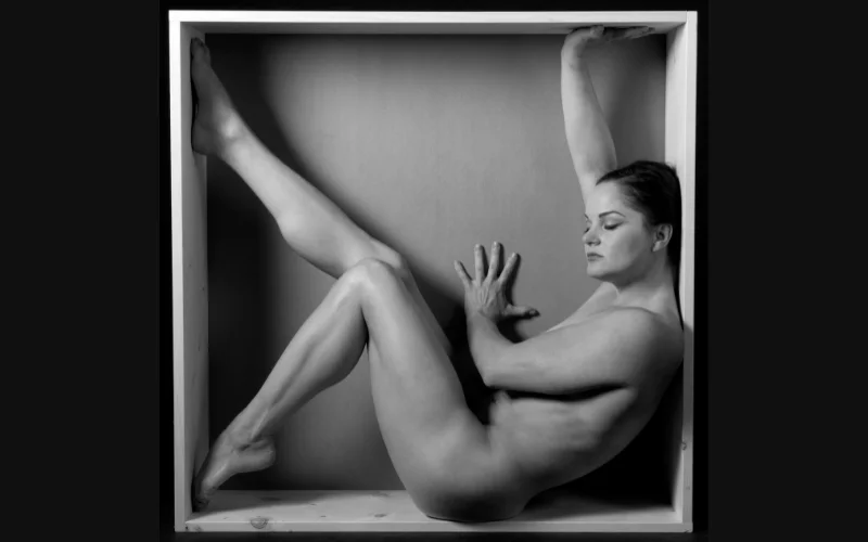 Fit in a frame abstract photography, nude pose in box with legs and hands stretched