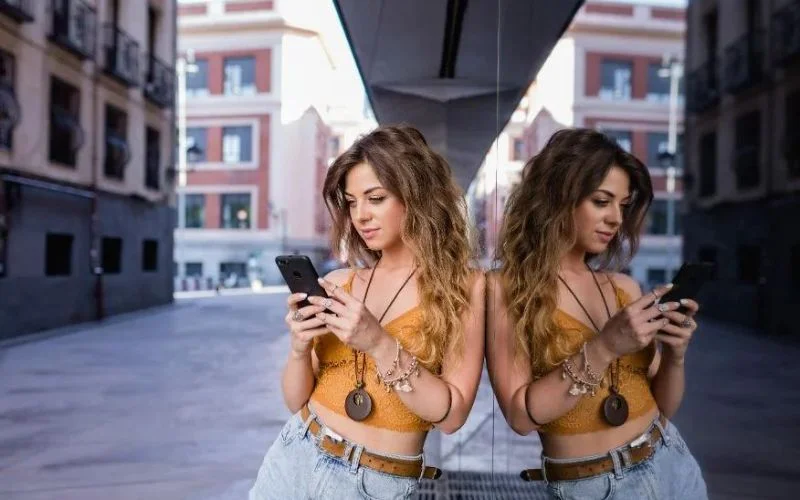 reflection of a girl watching phone