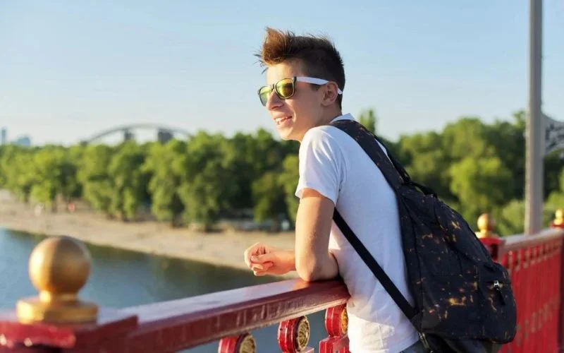 boy leaning on a fence