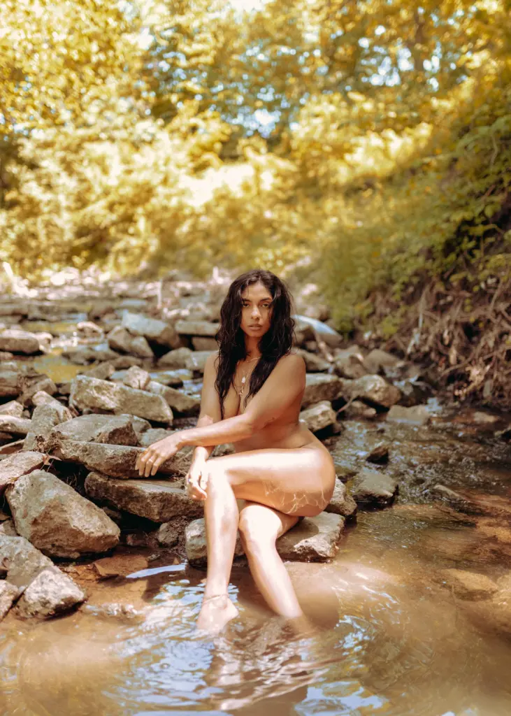 nude woman posing in a river