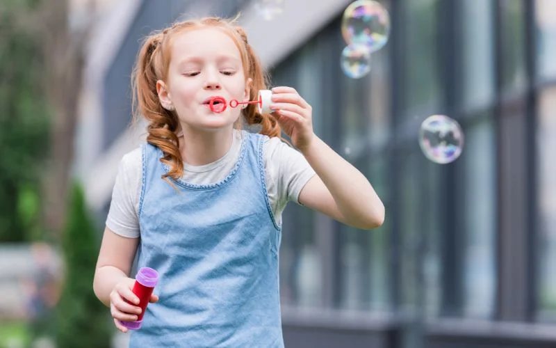 portrait of a small girl blowing bubbles