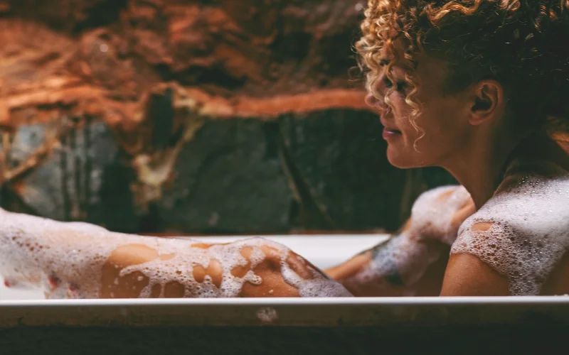 incorporate dark and moody theme, boudoir milk bath photography, sensual milk bath photoshoot, intimate milk bath photography, luxury milk bath photography