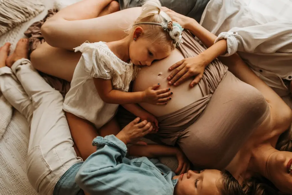 siblings on pregnant women's belly
