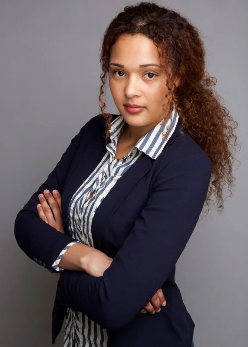 Businesswoman with folded arms in a professional corporate headshot pose.