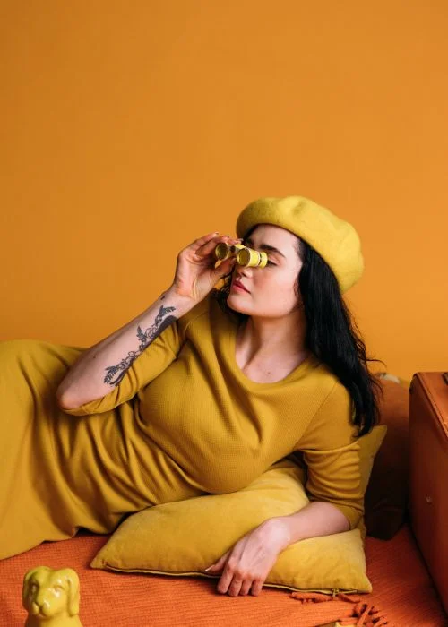 a model posing with binoculars