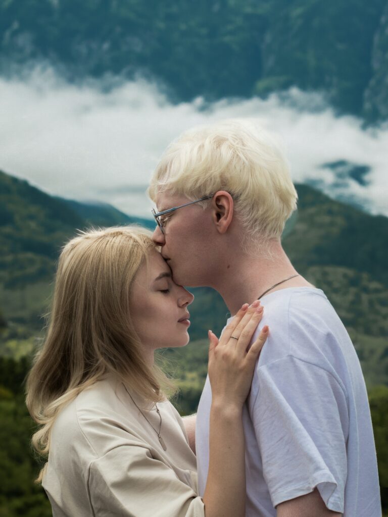 Man giving a woman kiss on forehead