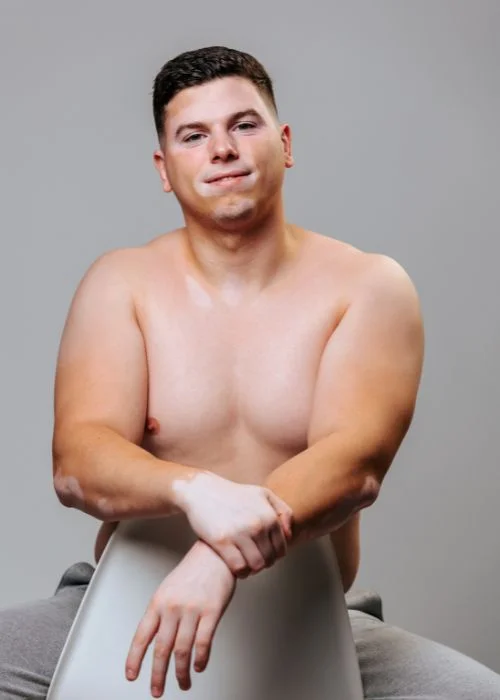 Plus size male boudoir pose highlighting confidence and natural expression