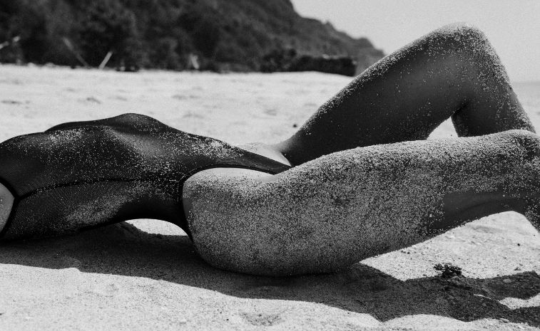 Model in lingerie covered in sand