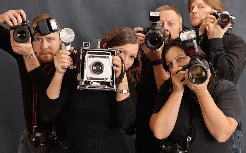 camera buying guide - photographers posing with cameras