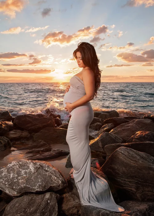 a pregnant woman posing against the sunset