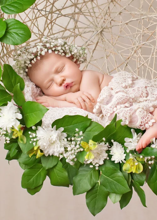 a cute baby posing on a flower arrangement
