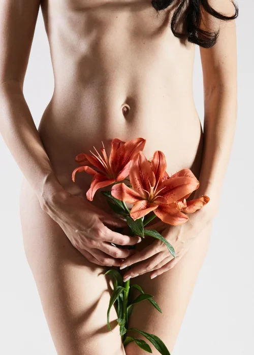 a nude model posing with flowers