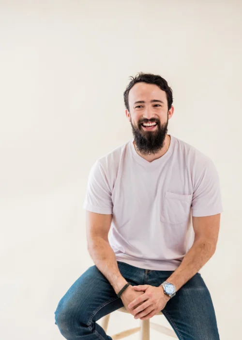 man posing on a stool