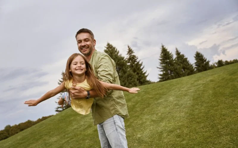 father and daughter posing outdoors