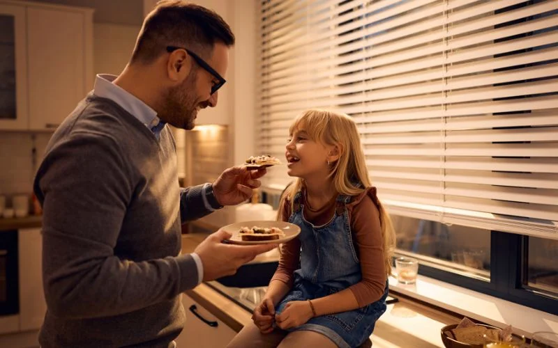 dad feeding a pizza to girl