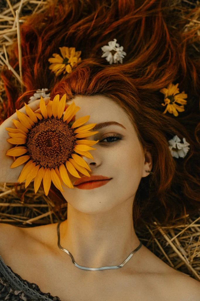 a woman posing with a sunflower for a portrait shot
