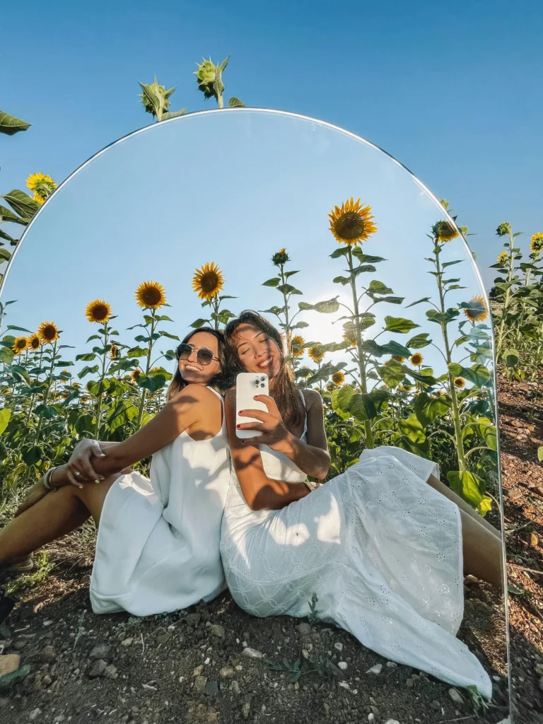 two girls posing in a sunflower field