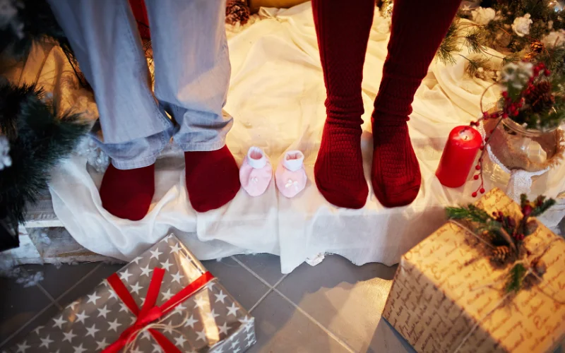 couple posing their stockings next to baby stockings