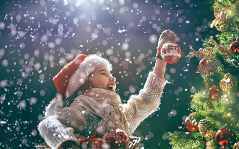 A child decorating a Christmas tree