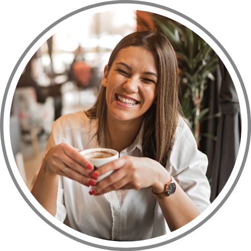 a woman laughing while sipping coffee