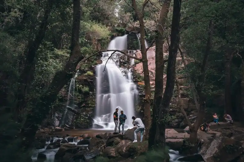 Nature-themed summer photoshoot at a waterfall with scenic backdrop