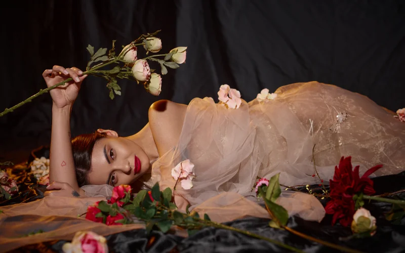woman posing with a floral romance themed boudoir photoshoot - boudoir photography tips