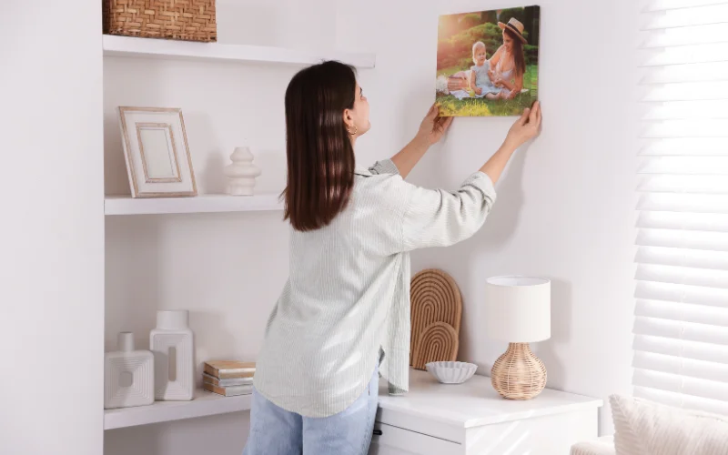 a woman hanging a portrait printed on a matte photo paper